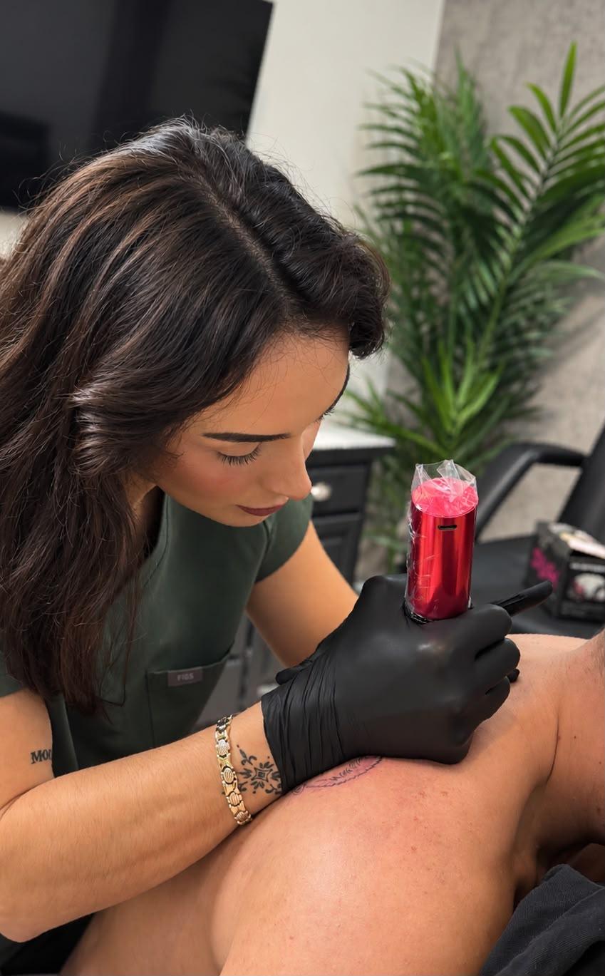 Amy tattooing a client's leg at her studio